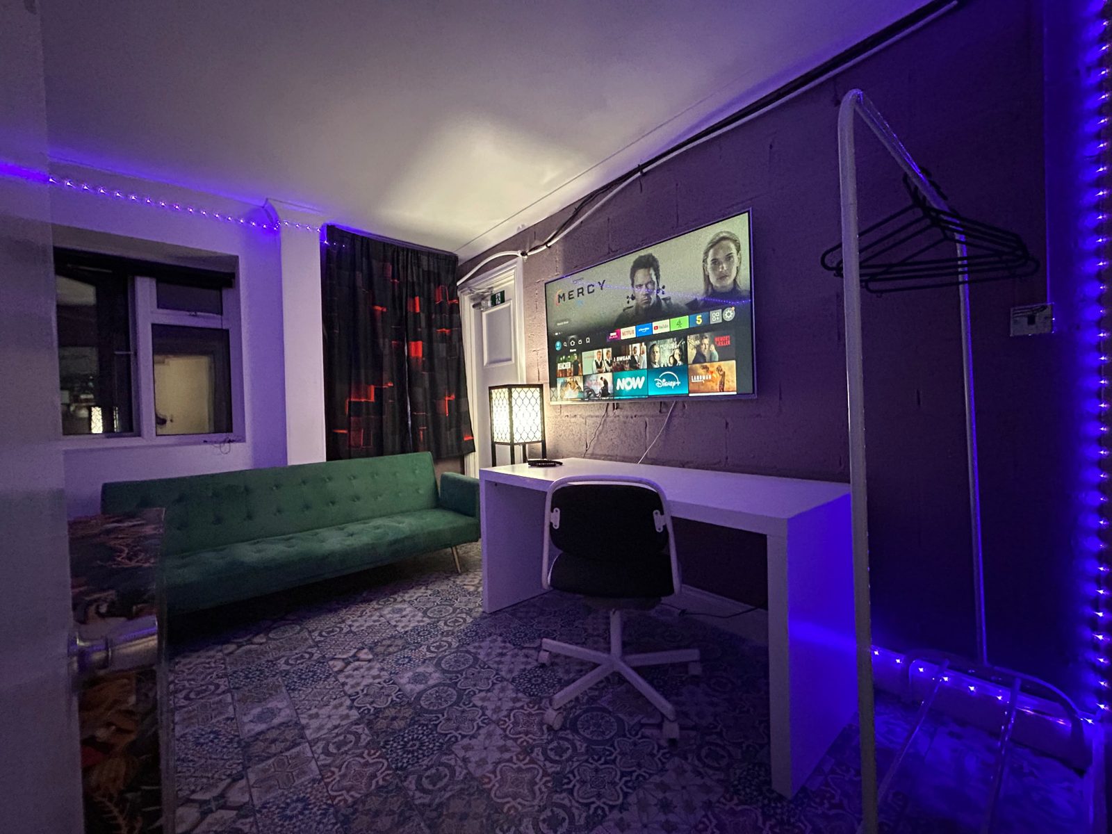 Basement office apartment with desk, office chair, large smart TV and mood lighting